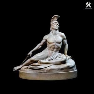 May include: A white marble-style sculpture of a reclining warrior wearing a crested helmet. The figure is seated on a rock-like base, holding a thin rod in one hand, with a draped cloth covering the lower body and a muscular, defined physique.