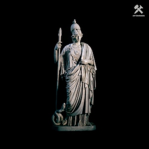 Puede incluir: Una estatua de mármol blanco de una figura femenina que lleva un casco y sostiene una lanza. La estatua está de pie sobre una base con una serpiente a sus pies.