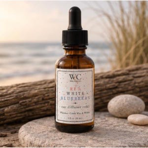 May include: An amber glass bottle with a black dropper cap and a white label. The label features the text WC, RED, WHITE, BLUEBERRY, car diffuser refill, and Whiskey Creek Wax & Wicks, with a volume of 1 fl oz (30 ml) printed on the front.