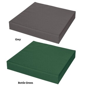 May include: Two square seat cushions, one grey and one bottle green. The cushions are made of a soft, textured fabric.