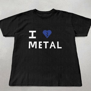 Può includere: Maglietta nera con una grafica bianca che dice "I ♥ METAL" con un cuore spezzato blu.