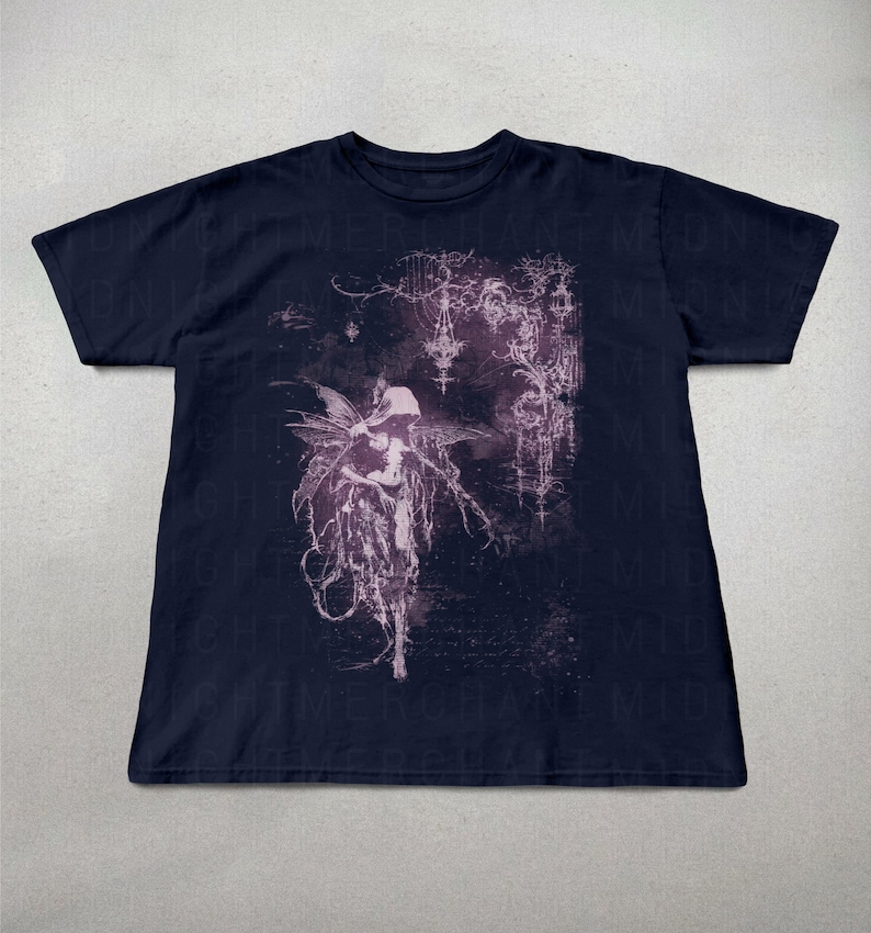 May include: Navy blue t-shirt featuring a detailed, gothic-inspired illustration of a winged figure with intricate details in shades of purple and white. The design has a dark, ethereal aesthetic.