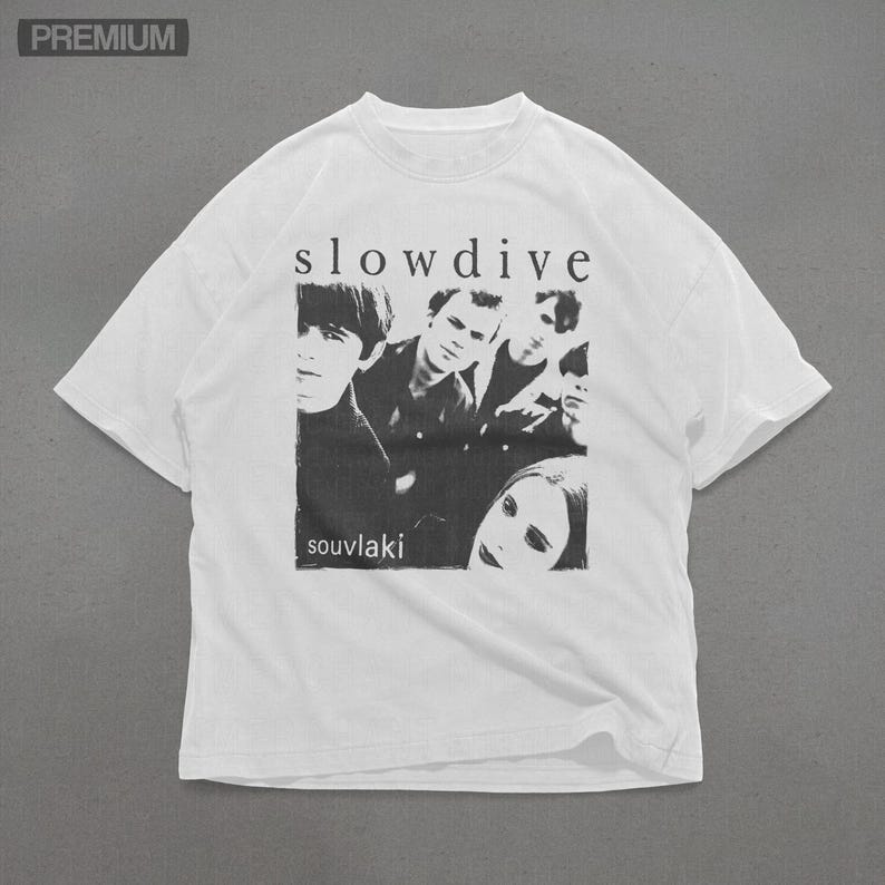 Puede incluir: Camiseta blanca con una imagen en blanco y negro de una banda, la palabra "slowdive" arriba y "souvlaki" abajo. La camiseta tiene cuello redondo y mangas cortas.