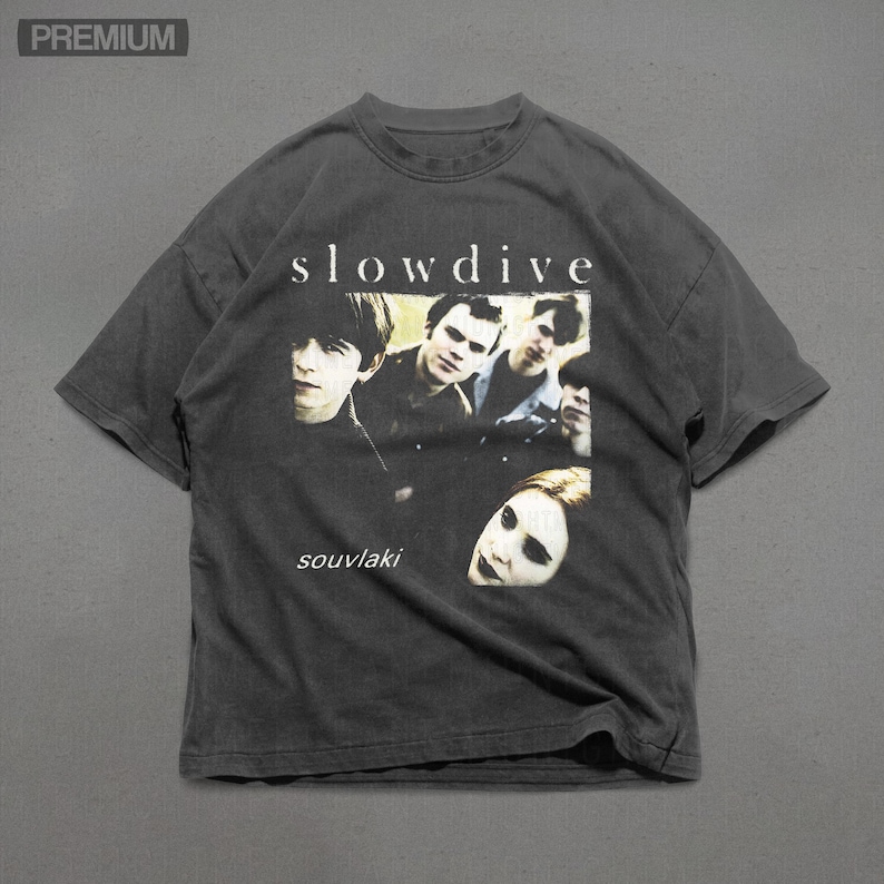 Puede incluir: Camiseta gris oscuro con la banda Slowdive y el t&iacute;tulo del &aacute;lbum "souvlaki" impreso. La camiseta tiene un aspecto vintage y desgastado.