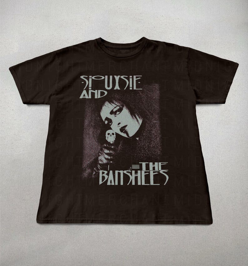 May include: Dark brown t-shirt featuring a black and white image of Siouxsie Sioux holding a skull, with the band name "Siouxsie and the Banshees" printed above and below the image in a gothic font.