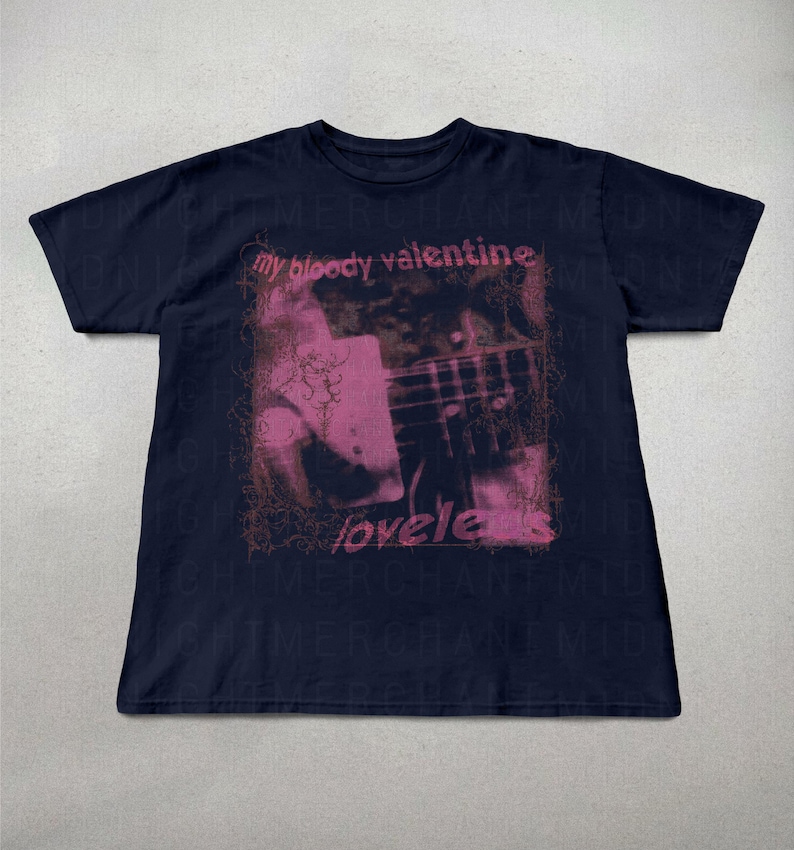 May include: Navy blue t-shirt featuring a pink and brown graphic with the text "my bloody valentine" and "loveless". The graphic appears to be a photograph of a guitar and a person. The shirt is a short-sleeved crew neck.