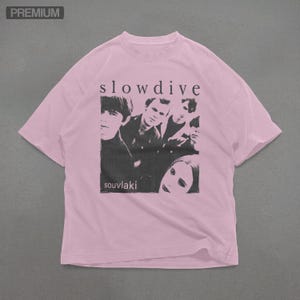 Puede incluir: Camiseta rosa claro con una imagen en blanco y negro de una banda. El texto "slowdive" est&aacute; encima de la imagen y "souvlaki" debajo. Cuello redondo y mangas cortas.