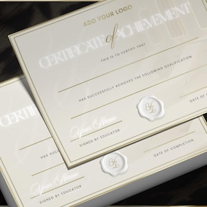May include: Two ivory-colored certificates with gold trim and the words "CERTIFICATE of ACHIEVEMENT" printed on them. The certificates have lines for information and a wax seal. The text "ADD YOUR LOGO" is also visible.