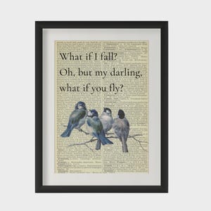 May include: A framed wall art print featuring four small birds perched on a branch over a vintage dictionary page background. The text reads: What if I fall? Oh, but my darling, what if you fly? The frame is black with a white mat border.