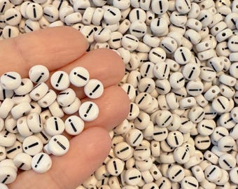 May include: A large quantity of white plastic beads with a black exclamation point printed on each bead.