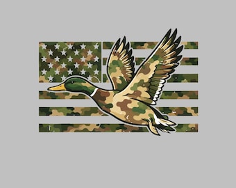 May include: A graphic illustration of a mallard duck in flight, featuring a camouflage pattern on its body and wings. Behind the duck is a stylized American flag design, also rendered in a green, brown, and tan camouflage color scheme.