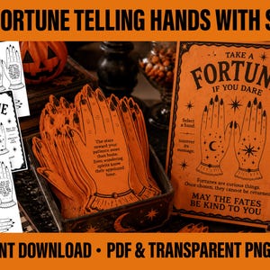 May include: A collection of orange paper hand-shaped cards featuring black ink illustrations of palms with celestial symbols and printed text. The cards are displayed in a dark box next to a larger sign with the text Take a Fortune If You Dare.