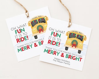 May include: Two white gift tags with a yellow school bus illustration and the text "Oh what fun it is to ride!" and "Merry & Bright". The tags are tied with twine.