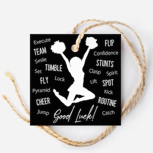 Op de afbeelding: Zwart-witte cadeaukaart met een silhouet van een cheerleader met pompoenen. De kaart bevat de woorden "Veel geluk!" en een lijst met cheerleading-termen zoals "Team", "Fly", "Tumble", "Stunts", "Routine", "Spot", "Flip" en "Cheer".