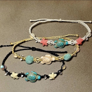 May include: Three layered bracelets with turquoise and white sea turtle charms, pink and white starfish charms, and white and gold beads.