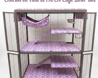 Può includere: Una gabbia per animali in metallo a più livelli con un set di rivestimenti Checkered Hearts FN/CN. L'interno include rivestimenti in tessuto viola con un motivo a cuori a scacchi sul pavimento, sulle piattaforme, sulle rampe e un'amaca.
