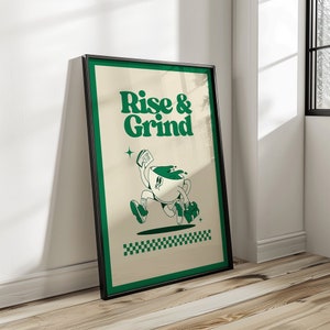 Puede incluir: Un póster enmarcado con un diseño verde y blanco. El póster presenta una taza de café de dibujos animados con una cara corriendo con un periódico en la mano. El texto "Rise & Grind" está escrito en letras verdes en el póster.