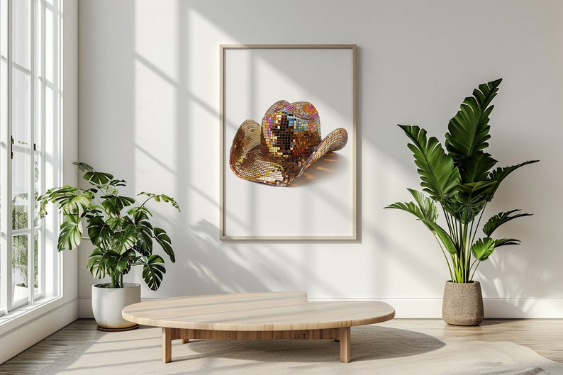 K&ouml;nnte beinhalten: Ein goldener Cowboyhut mit schillernden Pailletten, gerahmt und an einer wei&szlig;en Wand in einem modernen Ambiente ausgestellt.