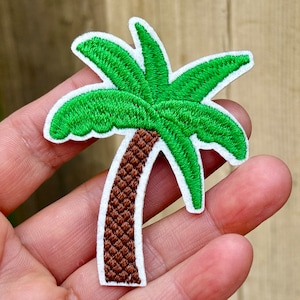 May include: Green embroidered palm tree patch with a brown trunk and white outline.