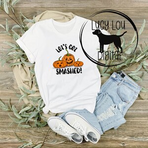 Puede incluir: Camiseta blanca con un gráfico de tres calabazas con caras y el texto "Let's get smashed!"