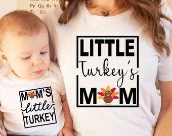 May include: A white t-shirt with the text "LITTLE Turkey's MOM" in black with a small turkey graphic. A white onesie with the text "MOM's little TURKEY" in black with a small turkey graphic.