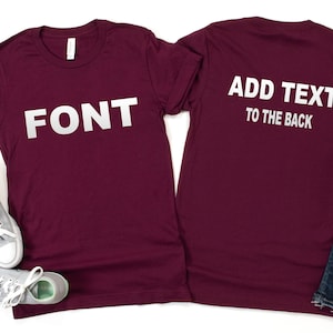 May include: Burgundy t-shirt with the word "FONT" printed in white on the front. The back of the shirt has the text "ADD TEXT TO THE BACK" printed in white.