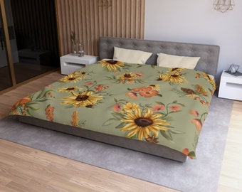 May include: A green duvet cover with a floral pattern featuring sunflowers, orange flowers, and green leaves. The duvet cover is on a bed with white and gray pillows.