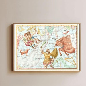 Op de afbeelding: Een vintage illustratie van een sterrenbeeldkaart met een stier, een man met een staf en twee figuren in de lucht. De kaart is ingelijst in een licht houten lijst en hangt aan een witte muur.