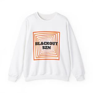 May include: White sweatshirt with a graphic print of a square with concentric orange and red lines. The text "BLACKOUT SZN" is printed in black inside the square.