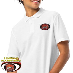 Pode incluir: Camisola polo branca com um logotipo ovalado vermelho e preto que diz "Gainesville Hogs Rugby Club".