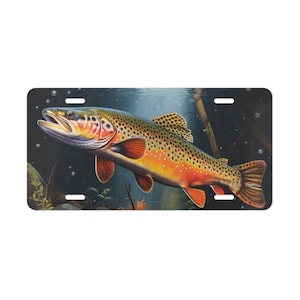 May include: A brown trout with orange and yellow markings swims in a dark blue and green underwater scene. The fish is facing left and has its mouth open. The background is a dark blue with green plants and rocks.