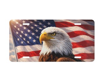 May include: Rectangular license plate featuring a majestic bald eagle with a yellow beak and piercing gaze. The background showcases a waving American flag with red and white stripes and a field of blue stars. The plate has pre-drilled holes.