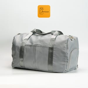 a gray duffel bag sitting on top of a white floor