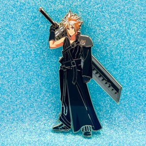 May include: Enamel pin featuring a character from Final Fantasy VII, with spiky blonde hair, a black outfit, and a large silver sword. The pin is set against a sparkly blue background.