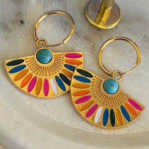 May include: A pair of gold-coloured fan-shaped earrings with a turquoise stone centre and colourful enamel accents. The earrings have a hoop closure and are decorated with orange, pink, white, blue, and green enamel.