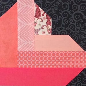 May include: A geometric quilt block featuring various patterned fabrics in shades of pink, coral, and white. The block includes a dark gray background with a swirl design.