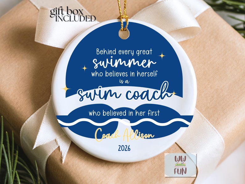 May include: A white ceramic ornament with a blue circular design featuring text that reads, "Behind every great swimmer who believes in herself is a swim coach." Gold text says "Coach Allison" and "2026". A gift box is included.