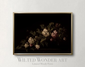 May include: A framed art print featuring a botanical illustration of white and pink flowers with green leaves against a dark background. The print is in a gold frame. The text "Wilted Wonder Art" and "Limited Moody Prints" is at the bottom.