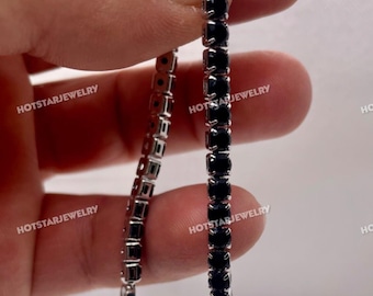 May include: A silver-toned tennis bracelet with a row of black gemstones. The bracelet is held up against a white background. The brand name "HOTSTARJEWELRY" is watermarked on the image.