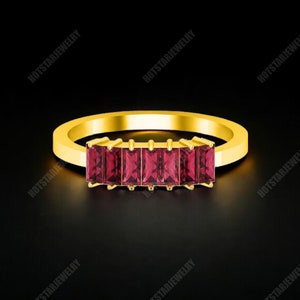 Puede incluir: Un anillo de banda de oro con cinco piedras preciosas rectangulares rojas engastadas en una fila.