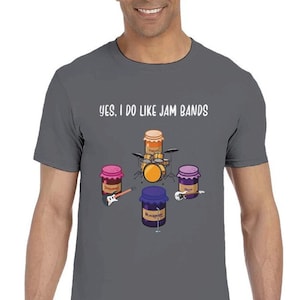 Op de afbeelding: Donkergrijs t-shirt met de witte tekst "YES, I DO LIKE JAM BANDS". De afbeelding toont jam potten als bandleden die drums, gitaar en bas spelen. De jam potten zijn gelabeld met Aardbei, Abrikoos, Braam en Druif.