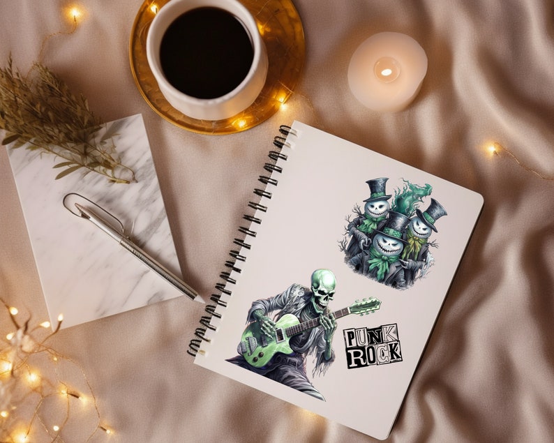 Op de afbeelding: Een notitieboek met twee stickers. E&eacute;n sticker toont een skelet dat een groene elektrische gitaar bespeelt met de tekst "Punk Rock". De andere sticker toont drie groene sneeuwpoppen met zwarte hoeden.