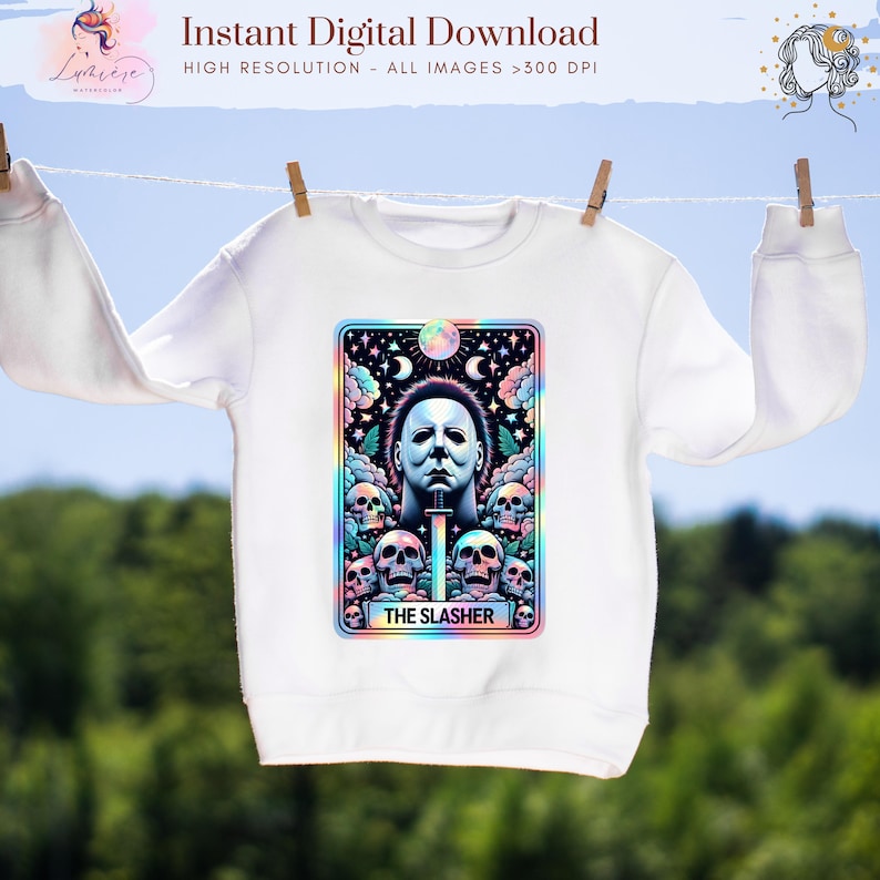 May include: White sweatshirt with a colorful graphic featuring a portrait of a character with a knife, surrounded by skulls, and the text "THE SLASHER". The sweatshirt is hanging on a clothesline.