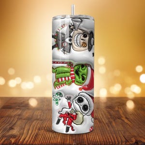 Puede incluir: Un vaso blanco con personajes de Pesadilla antes de Navidad. El dise&ntilde;o incluye a Jack Skellington con gorro de Pap&aacute; Noel, el Grinch y otros elementos festivos. El vaso tiene una pajita y est&aacute; sobre un fondo borroso.
