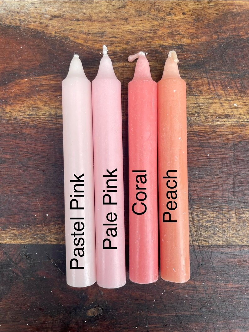 Może przedstawiać: Cztery cylindryczne świece stożkowe ustawione obok siebie. Świece mają nadrukowany tekst na swoich powierzchniach: Pastel Pink, Pale Pink, Coral oraz Peach. Każda świeca ma spiczastą g&oacute;rę i gładkie wykończenie z wosku w jednolitym kolorze.