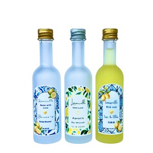 May include: Three small limoncello bottles with gold and silver caps. Each bottle has a unique label with text and lemon illustrations. The bottles are for a bridal shower, a Bar Mitzvah, and a wedding.