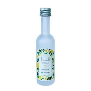 May include: A frosted glass bottle with a silver cap, labeled "Limoncello" with a lemon and leaf design. The label also includes "With Love," a heart, "Aaron's Bar Mitzvah," and the date 12.18.2025.