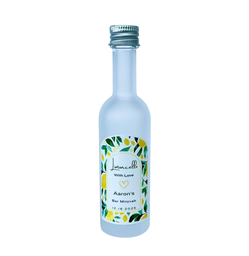 May include: A frosted glass bottle with a silver cap, labeled "Limoncello" with a lemon and leaf design. The label also includes "With Love," a heart, "Aaron's Bar Mitzvah," and the date 12.18.2025.