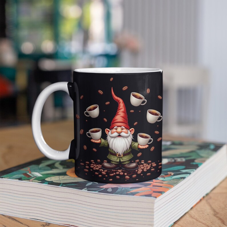 A black coffee mug with a gnome design and coffee cups on its surface, placed on top of a book.