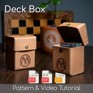 May include: Two brown leather deck boxes, one open and one closed, with a logo on the front. The open box reveals a stack of cards. The text "Deck Box" is at the top, and "Pattern & Video Tutorial" is at the bottom.